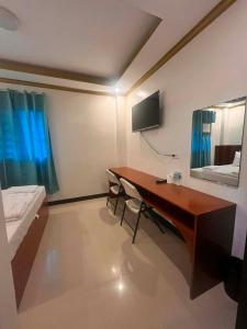 a room with a desk and a bed and a mirror at Optimun Inn in Davao City +18 photos