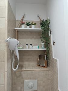 a shower with a phone and plants in a bathroom at Cosy Space Apartment in Tychy +21 photos