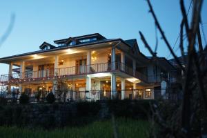 a large house with lights on at Bir Nest Hostel in Bīr