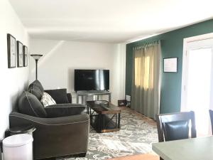 a living room with a couch and a flat screen tv at 4 Bedroom Vacation House With Pikes Peak view Pet-friendly in Aurora