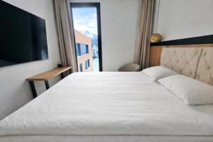 a bedroom with a large white bed with a window at Apartament - Vidok 301 in Olsztyn