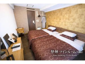 a hotel room with two beds and a desk at Comfort stay Miyabi in Chichibu +41 photos
