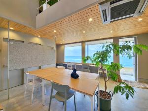 a conference room with a wooden table and chairs at ゲストハウス＆カフェ　ハレテル in Masuda