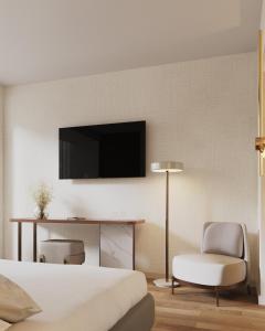 a bedroom with a bed and a desk and a television at Tivoli Coimbra Hotel in Coimbra