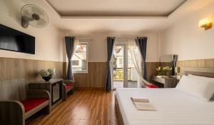 a bedroom with a bed and a desk and a tv at Phương Châu Holiday Hotel Đà Lạt in Da Lat