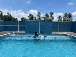 a woman swimming in a swimming pool at Natures Nest Araku Resort in Araku