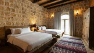a bedroom with two beds and a brick wall at Golden Heights Resort in Al Ḩanī +98 photos