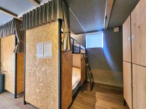 a room with a bunk bed and a staircase at ゲストハウス＆カフェ　ハレテル in Masuda