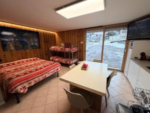 a bedroom with a bed and a desk and a table at Residenze Vezza - La Corteccia- in Vezza dʼOglio