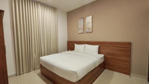 a bedroom with a bed with white sheets and a window at Al Khaleej Plaza Furnished Hotel Apartments in Ajman 