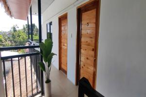 a hallway with wooden doors and a balcony at Eva's Guest House in General Luna