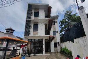 a tall white building with a window at Eva's Guest House in General Luna