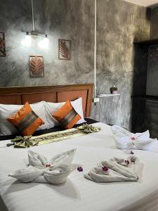 a bedroom with two beds with towels on them at Lanta natural hut garden in Ko Lanta +53 photos