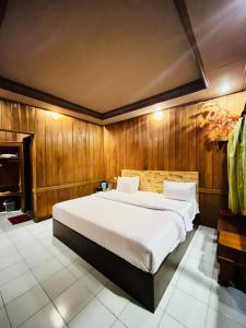 a bedroom with a large bed with wooden walls at Cemara Indah Hotel in Bromo +187 photos