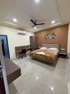 a bedroom with a large bed and a desk at Kailash Residency in Hospet