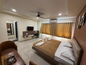 a bedroom with a bed and a desk in a room at Kailash Residency in Hospet
