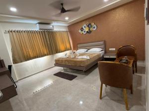 a bedroom with a bed and a table and chairs at Kailash Residency in Hospet