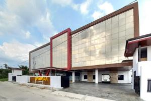 a large building with a large glass facade at Sans Vibes Viandara Pekanbaru in Parit
