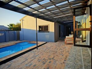 a patio with a swimming pool and a pergola at Kubata Diame B&B in Cape Town