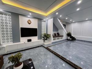 a large living room with a television and a staircase at A Luc House in Cat Ba