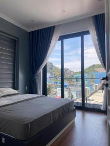a bedroom with a bed and a large window at A Luc House in Cat Ba