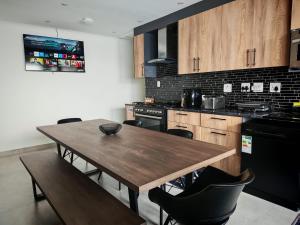 a kitchen with a wooden table and black appliances at Kubata Diame B&B in Cape Town