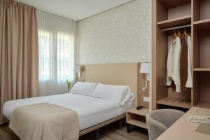 ein Hotelzimmer mit Bett, Schreibtisch und Fenster in der Unterkunft Hostal Centric in Barcelona