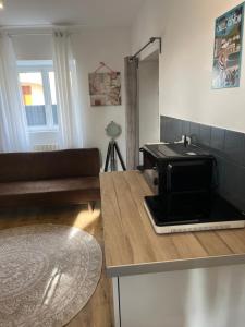 a kitchen with a microwave on top of a counter at Studio Privatif - Ancienne Maison Vigneronne in Châtel-Guyon