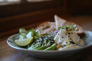 a plate of food with fruit and vegetables on a table at Dennehof Karoo Guesthouse in Prince Albert