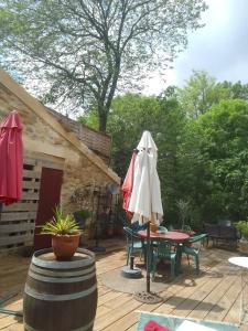 a patio with a table and an umbrella on a deck at atypical house garden in Saint-Paulet-de-Caisson