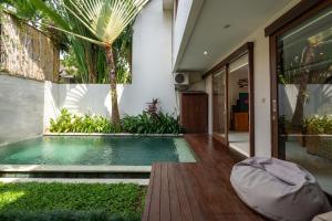 a swimming pool in the middle of a house at Du Ciel Villa by Betterplace in Canggu