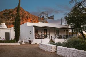 a white house with a windmill on top of it at Dennehof Karoo Guesthouse in Prince Albert