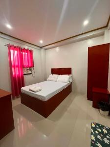 a bedroom with a bed and a red window at Optimun Inn in Davao City