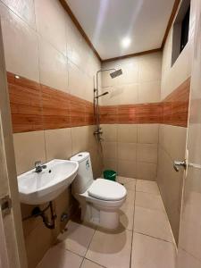 a bathroom with a toilet and a sink at Optimun Inn in Davao City