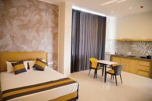 a hotel room with a bed and a table and chairs at Lotus Luxury Residencies in Negombo