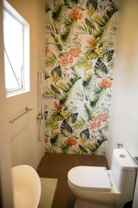 a bathroom with a toilet and a floral wallpaper at Lotus Luxury Residencies in Negombo +42 photos