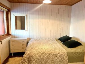a bedroom with a bed and a dresser and a mirror at Aurora beach house in Trondalen