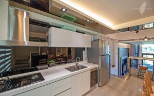 a kitchen with white cabinets and a stainless steel refrigerator at Migo Homestay in Yilan City +30 photos