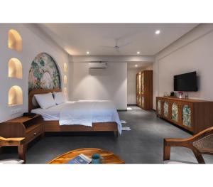 a bedroom with a bed and a flat screen tv at Larissa Resort in Nashik
