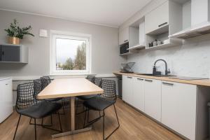 a kitchen with white cabinets and a wooden table and chairs at Reldor Motell in Pärnu