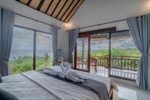 a bedroom with a bed with a view of the ocean at Gistari Inn & Restaurant in Seraya +78 photos