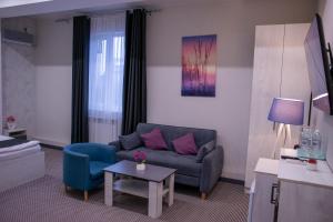 a living room with a couch and a table at Tengri Hotel in Aktau