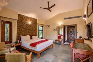 a bedroom with a bed and a stone wall at Tiger Camp Resort A River Access Property in Dhikuli +201 photos