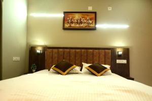 a bedroom with a large bed with a picture on the wall at Shade trees in Padinjarathara +7 photos