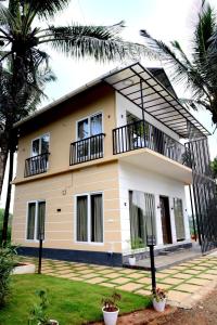 a house with two balconies on top of it at Shade trees in Padinjarathara
