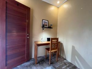 ein Zimmer mit einem Holzschreibtisch, einem Stuhl und einer Tür in der Unterkunft Bitang's Guesthouse - Starlink Ready in Burgos