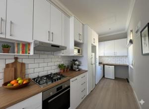 a kitchen with white cabinets and a bowl of fruit on the counter at The Hidden Gem in Oakdale