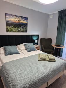 a bedroom with a large bed and a chair at Willa Elżbieta - komfortowy wypoczynek, znakomite recenzje Gości in Karpacz