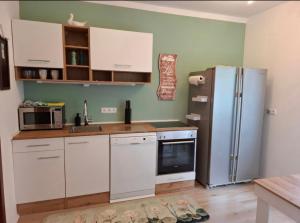 a kitchen with white cabinets and a refrigerator at Sterisches Daham in Aflenz Kurort