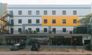 a building with cars parked in a parking lot at Algers Suites Bayan-Bayanan Marikina City in Manila